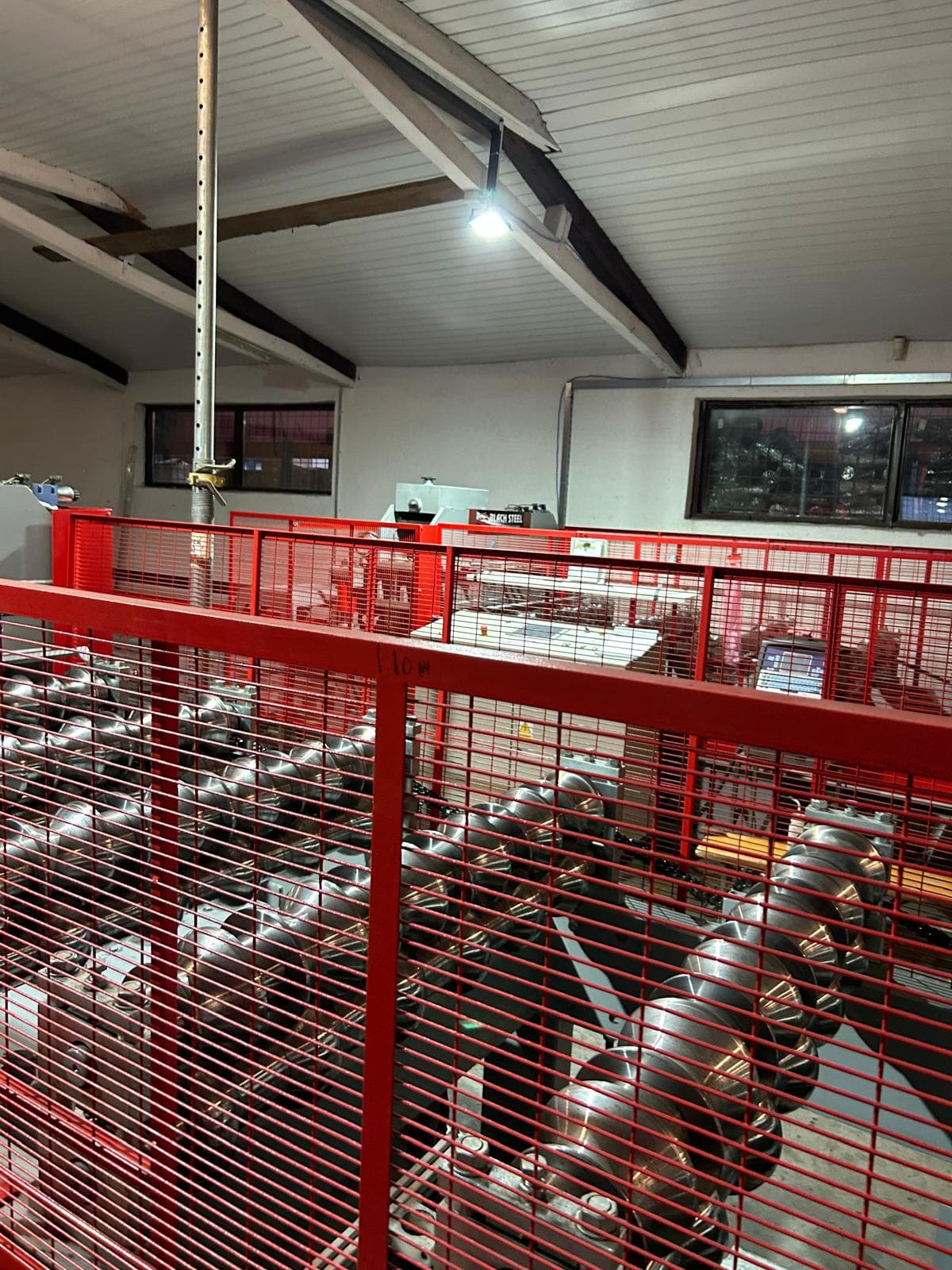 Industrial machinery behind safety cage with sensors for predictive maintenance monitoring